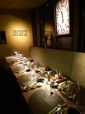 a long table with wine glasses and a clock at Den Ommegang in Halle