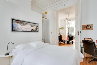 a white bedroom with a bed and a chair at Saint Catherine Art Residence in Brussels