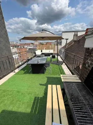 a patio with a picnic table and an umbrella at Duplex avec terrasse quartier européen in Brussels