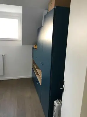 a blue cabinet in a room with a window at Duplex avec terrasse quartier européen in Brussels