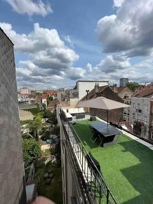 a balcony of a building with a picnic table and an umbrella at Duplex avec terrasse quartier européen in Brussels