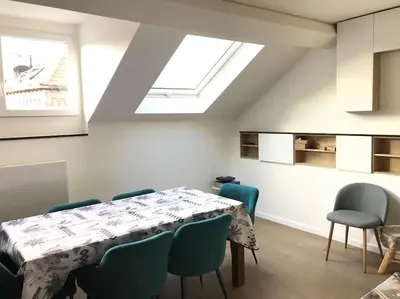 a dining room with a table and chairs and a skylight at Duplex avec terrasse quartier européen in Brussels