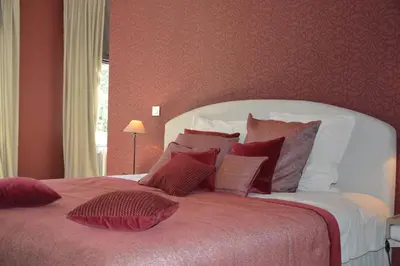 a bedroom with a large bed with red walls at B & B Landhuis Ter Velt in Melle