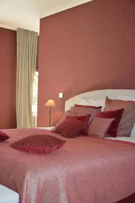 a bedroom with a large bed with red walls at B & B Landhuis Ter Velt in Melle