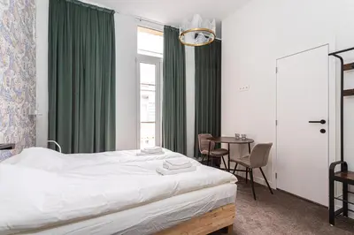 a bedroom with a bed and a table with chairs at Room6 Van Lerius in Antwerp