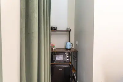 a room with a curtain and a shelf with a microwave at Room6 Van Lerius in Antwerp