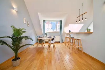 a dining room and kitchen with a table and chairs at Heart of Grand Place - Stunning 2BR Duplex in Brussels