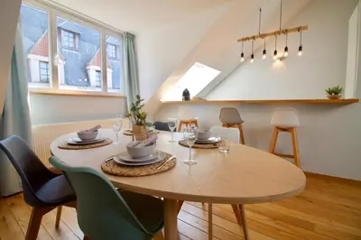 a dining room with a table and chairs and a table at Heart of Grand Place - Stunning 2BR Duplex in Brussels