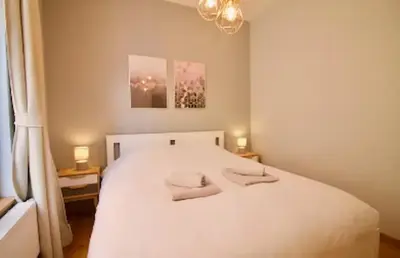 a bedroom with a white bed with two pillows on it at Heart of Grand Place - Stunning 2BR Duplex in Brussels