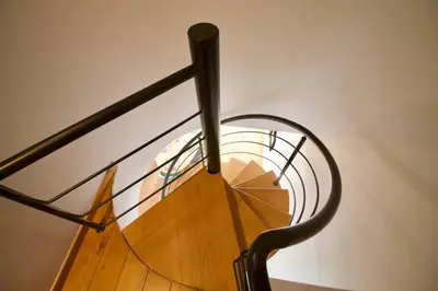 a spiral staircase with a metal railing at Heart of Grand Place - Stunning 3BR Triplex in Brussels