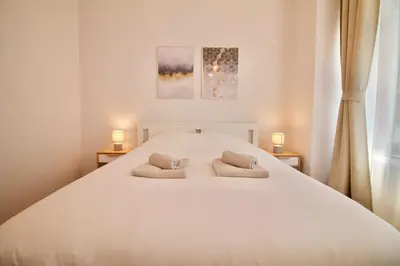 a bedroom with a large white bed with two pillows at Heart of Grand Place - Stunning 3BR Triplex in Brussels