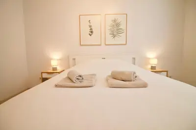 a bedroom with a white bed with two towels on it at Heart of Grand Place - Stunning 3BR Triplex in Brussels
