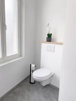 a white bathroom with a toilet and a window at New Cozy Apartments In Porte de HAL in Brussels