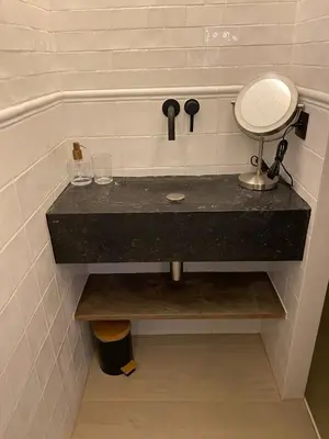 a bathroom sink with a mirror and two glasses at Roxy's Fishmarket in Leuven