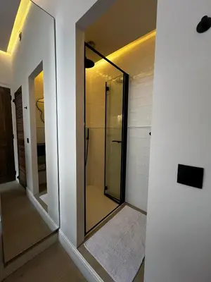 a bathroom with a walk in shower and a mirror at Roxy's Fishmarket in Leuven