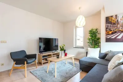 a living room with a couch and a tv at Jette Expo Duplex Residence in Brussels