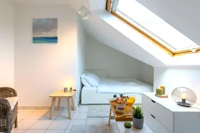 a living room with a bed and a window at Jette Expo Duplex Residence in Brussels