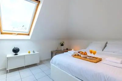 a bedroom with a bed with a tray of food on it at Jette Expo Duplex Residence in Brussels