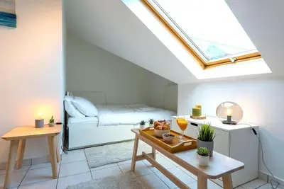 a attic room with a bed and a table at Jette Expo Duplex Residence in Brussels