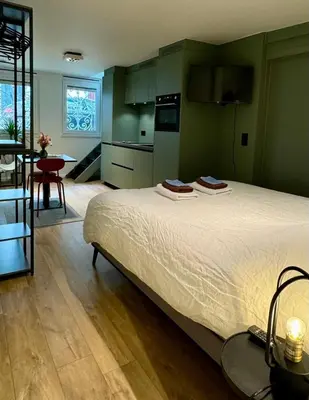a bedroom with a large bed and a kitchen at J1 - Urban studio in Antwerp in Antwerp