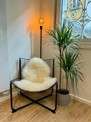 a chair with a furry pillow in a room with a plant at J1 - Urban studio in Antwerp in Antwerp