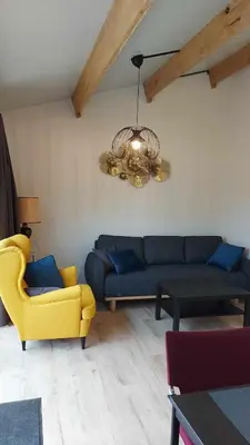 a living room with a blue couch and a yellow chair at Juffertje in't groen in Tessenderlo