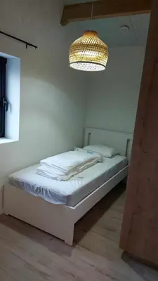 a bed in a room with a chandelier at Juffertje in't groen in Tessenderlo