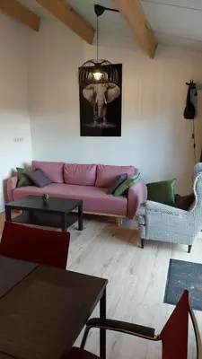 a living room with a pink couch and a table at Juffertje in't groen in Tessenderlo
