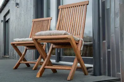 two wooden rocking chairs sitting on a balcony at Meerbeek Unwind in Kortenberg