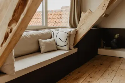 a bench in a room with a window at Stil 1827 in Sint-Laureins