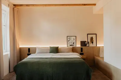 a bedroom with a bed with a green blanket at Stil 1827 in Sint-Laureins