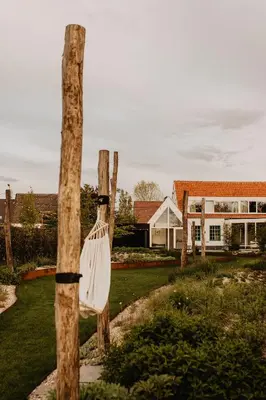 a white bag hanging from a tree in a yard at Stil 1827 in Sint-Laureins