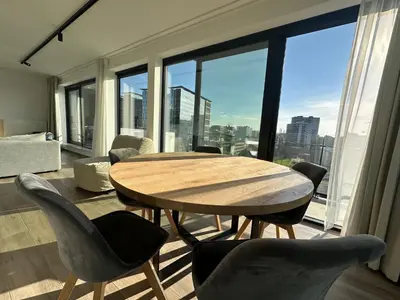 a table and chairs in a room with a large window at Penthouse Apartment in Brussels with Stunning View in Brussels