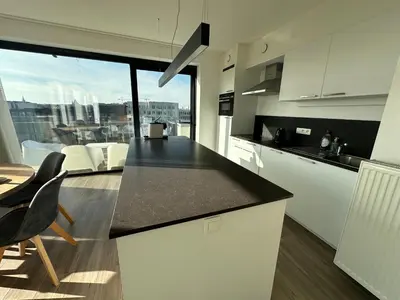 a kitchen with a counter and a table and chairs at Penthouse Apartment in Brussels with Stunning View in Brussels