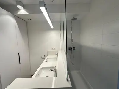 a white bathroom with a sink and a mirror at Penthouse Apartment in Brussels with Stunning View in Brussels