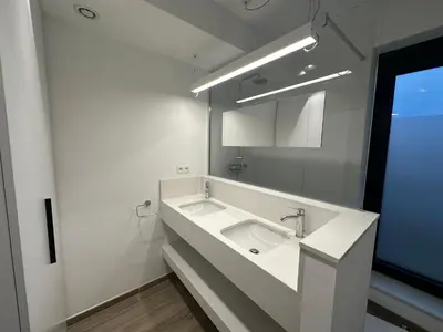 a white bathroom with a sink and a mirror at Penthouse Apartment in Brussels with Stunning View in Brussels