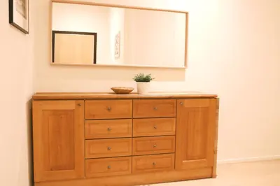 a wooden dresser with a mirror on a wall at Luxury 2 Bedroom - Antwerp City Centre in Antwerp