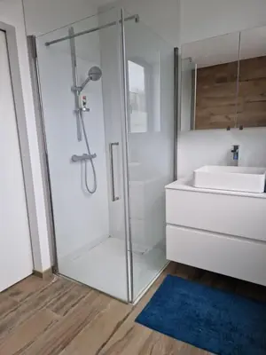 a bathroom with a glass shower and a sink at Volledige gezinswoning te huur in Mechelen
