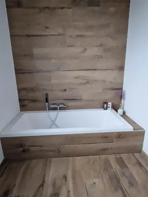 a bath tub with a wooden wall at Volledige gezinswoning te huur in Mechelen