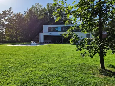 a building with a green lawn in front of it at Volledige gezinswoning te huur in Mechelen