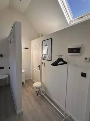 a room with a white wall and a chair and a window at Skyroof à Ixelles - Viaduc in Brussels
