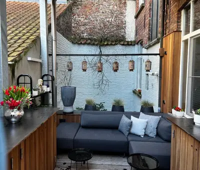 a patio with a blue couch on a balcony at Agelandkaai (.be) Free Parking in Ghent