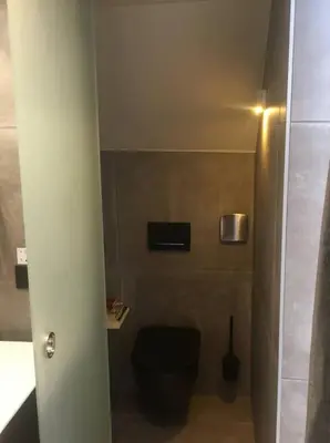 a bathroom with a black toilet in a room at Agelandkaai (.be) Free Parking in Ghent