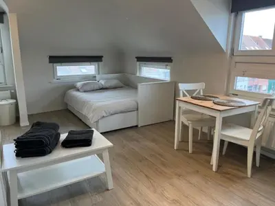 a bedroom with a bed and a table and a table and chairs at Sint-Amandstraat studio B4 in Ghent
