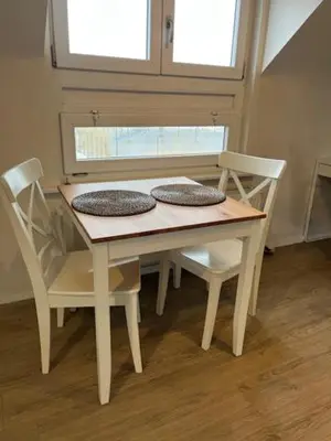 a white table with two chairs and two windows at Sint-Amandstraat studio B4 in Ghent