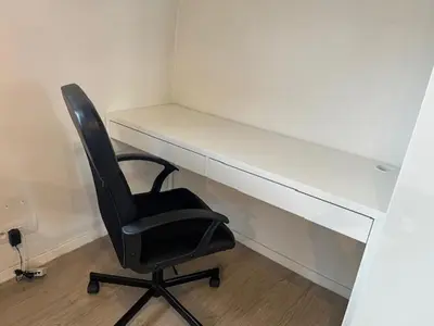 a black chair sitting in front of a white desk at Sint-Amandstraat studio B4 in Ghent