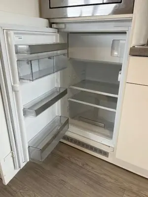 an empty refrigerator with its door open in a kitchen at Sint-Amandstraat studio B4 in Ghent