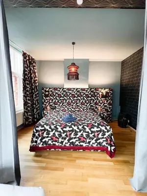 a bedroom with a bed with a patterned bedspread at Le FauBourg Suites in Antwerp