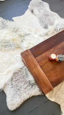 a wooden cutting board sitting on top of a white rug at Le FauBourg Suites in Antwerp