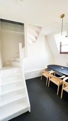 a room with a staircase and a table and chairs at Le FauBourg Suites in Antwerp